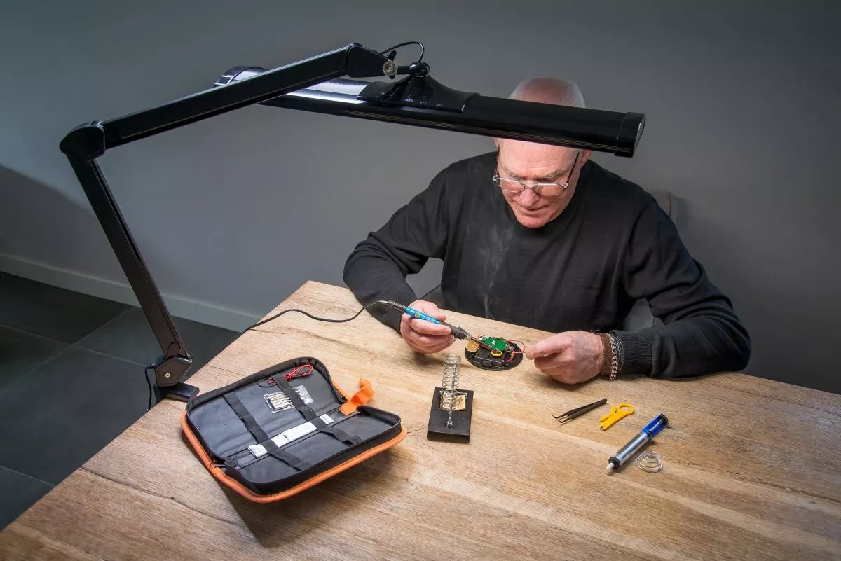 SBR Professional Black Daylight Lamp — 45W LED desk lamp for jewelers and precision work. Man working with the sbr lamp.